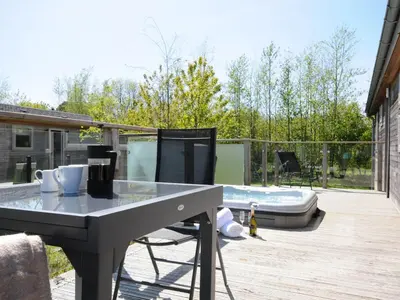 a patio with a table and chairs and a hot tub at 7 Meadow Retreat in Liskeard