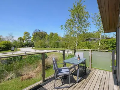 a patio with a table and chairs on a deck at 11 Meadow Retreat in Liskeard