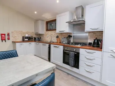 a kitchen with white cabinets and a stove top oven at 2 Southern Place in Liskeard
