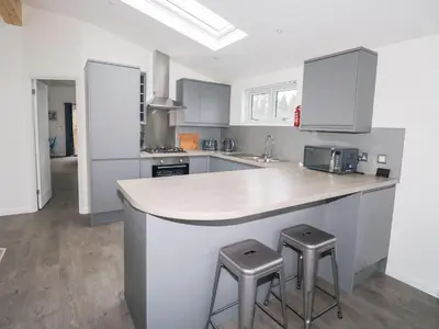 a kitchen with a counter and two stools at 1 Southern Place in Liskeard