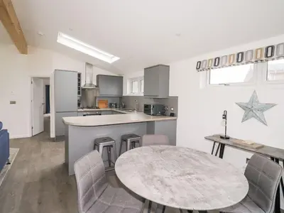 a kitchen with a table and a table and chairs at 1 Southern Place in Liskeard