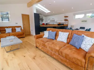 a living room with two brown couches and a table at 21 Meadow Retreat in Liskeard