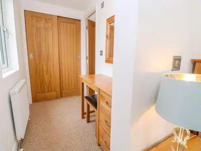 a room with a wooden desk and a blue lamp at 21 Meadow Retreat in Liskeard