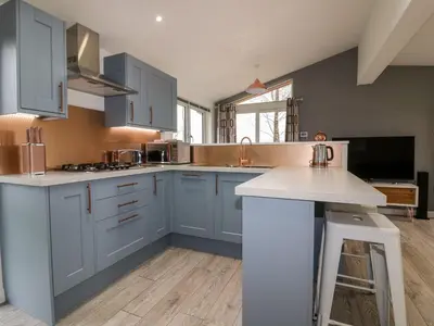 a kitchen with blue cabinets and a white counter top at 19 Meadow Retreat in Liskeard