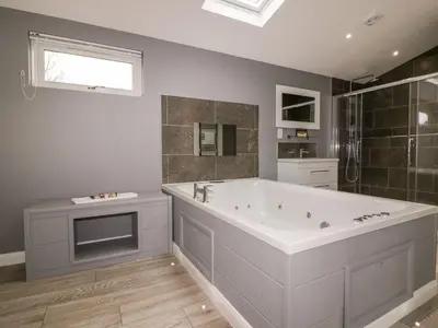 a bathroom with a large bath tub and a window at 19 Meadow Retreat in Liskeard