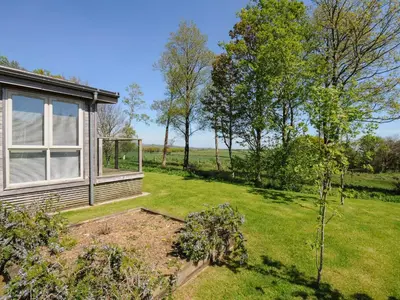 a garden with a house and trees in the background at 19 Meadow Retreat in Liskeard