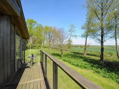 a wooden porch of a house with a table on it at 19 Meadow Retreat in Liskeard