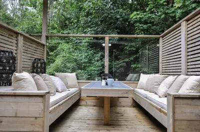 a wooden pergola with benches and a table on a deck at 24 Meadow Retreat in Liskeard