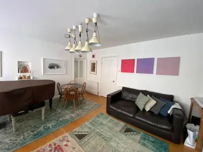 a living room with a black couch and a table at Clarendon House in Saint Columb Major
