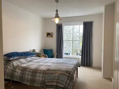 a bedroom with a bed and a large window at Clarendon House in Saint Columb Major