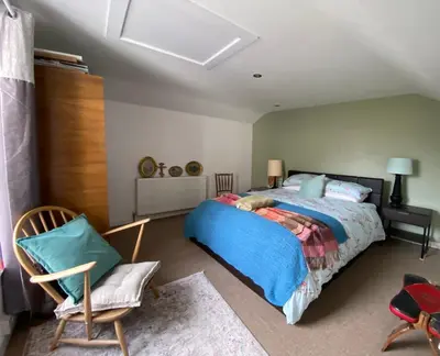 a bedroom with a bed and a chair at Clarendon House in Saint Columb Major