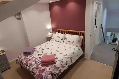a bedroom with a bed with pink and white sheets at Willow Cottage Cosy Cornish Rural Retreat - Dog Friendly Cornwall in Ponsanooth