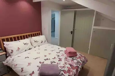 a bedroom with a bed with pinkpillows on it at Willow Cottage Cosy Cornish Rural Retreat - Dog Friendly Cornwall in Ponsanooth