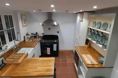 a kitchen with wooden counters and a stove top oven at Willow Cottage Cosy Cornish Rural Retreat - Dog Friendly Cornwall in Ponsanooth