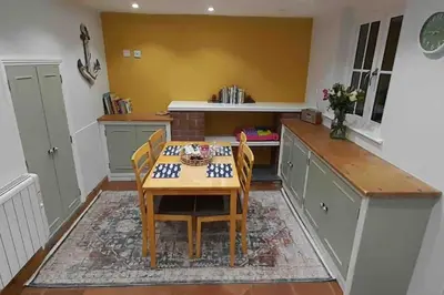 a kitchen with a table and chairs in a room at Willow Cottage Cosy Cornish Rural Retreat - Dog Friendly Cornwall in Ponsanooth