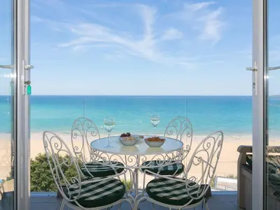 a table and chairs with a view of the beach at Surf and Sand in St Ives