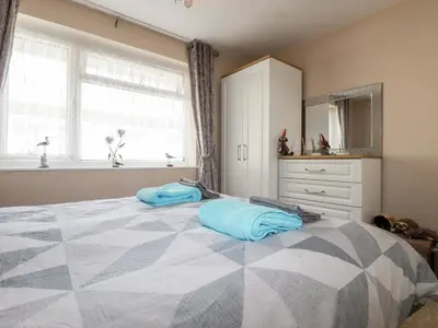 a bedroom with a large bed with blue pillows on it at Smugglers in Liskeard