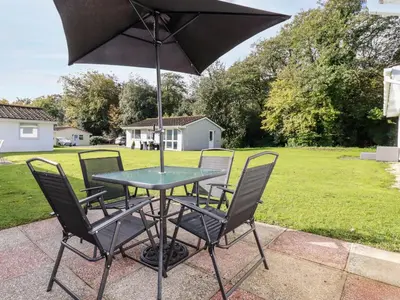 a table with four chairs and an umbrella at Smugglers in Liskeard