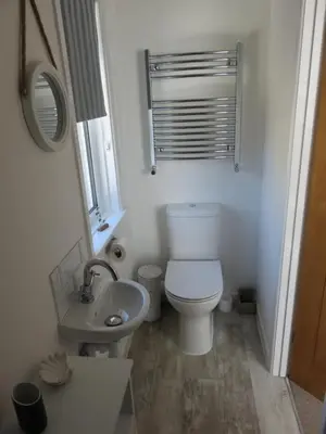 a white bathroom with a toilet and a sink at The Retreat St Ives in St Ives
