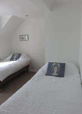 a bedroom with two beds with a pillow on it at The Retreat St Ives in St Ives