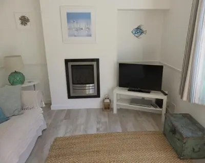 a living room with a tv and a bed at The Retreat St Ives in St Ives