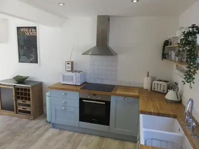 a kitchen with blue cabinets and a stove top oven at The Retreat St Ives in St Ives