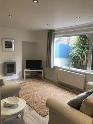 a living room with a couch and a large window at The Retreat St Ives in St Ives