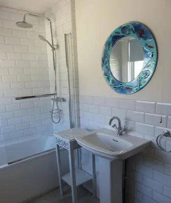 a bathroom with a sink and a mirror and a tub at The Retreat St Ives in St Ives