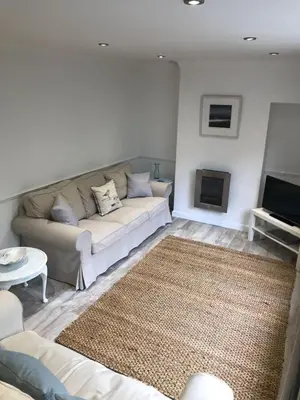 a living room with a couch and a television at The Retreat St Ives in St Ives