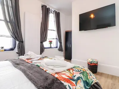 a bedroom with a bed with a tv on the wall at The Dynar in Helston