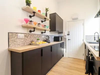 a kitchen with black cabinets and a counter at The Dynar in Helston