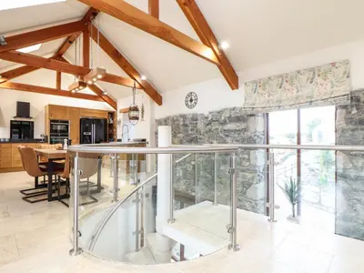 a kitchen and dining room with a glass table at Pol Glas Hall in Helston