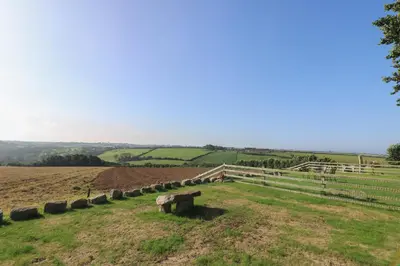 a bench sitting in the middle of a field at Pol Glas Hall in Helston