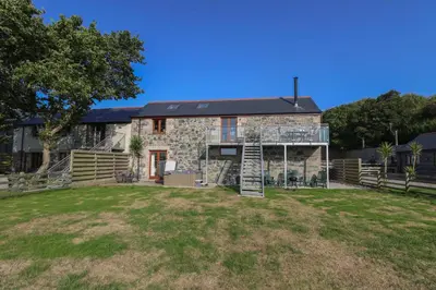 a stone house with a large yard at Pol Glas Hall in Helston