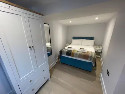 a small bedroom with a bed and a mirror at Seasteps Padstow in Padstow