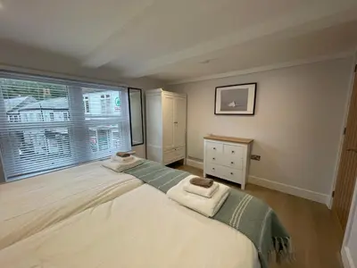 a bedroom with a large bed and a window at Seasteps Padstow in Padstow