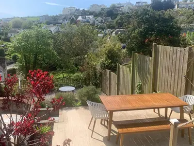 a patio with a table and chairs and a fence at Mevagissey Holiday Home - sea view and parking in St Austell