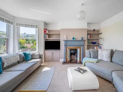 a living room with a couch and a fireplace at Mevagissey Holiday Home - sea view and parking in St Austell