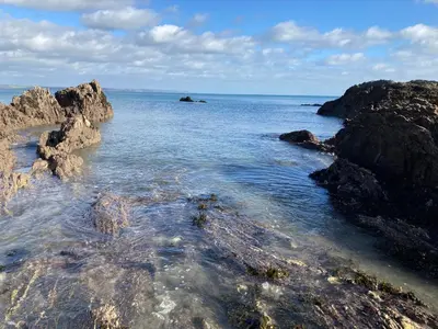 a view of the ocean with rocks in the water at Mevagissey Holiday Home - sea view and parking in St Austell