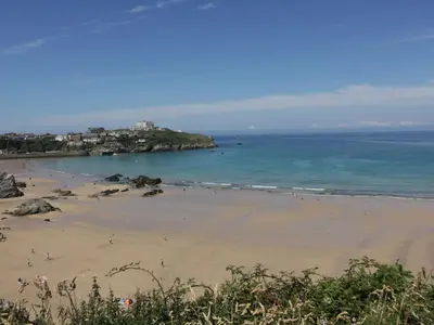 a beach with a group of people in the water at 9 Headland Point in Newquay