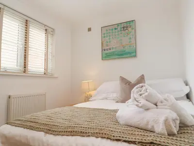a bedroom with a bed with white towels on it at 9 Headland Point in Newquay