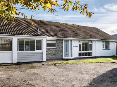 a white house with a garage at Obo's Retreat in Wadebridge
