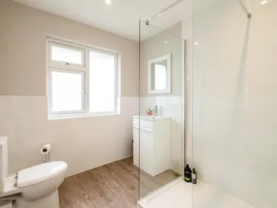 a bathroom with a toilet and a glass shower at Obo's Retreat in Wadebridge