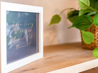 a picture frame sitting on a table next to a plant at Obo's Retreat in Wadebridge