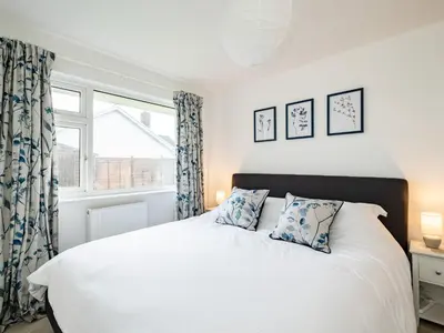 a bedroom with a white bed and a window at Obo's Retreat in Wadebridge