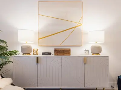 two lamps on top of a cabinet in a living room at Driftwood in Newquay