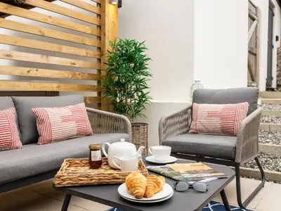 a patio with a coffee table with croissants at Driftwood in Newquay
