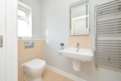 a white bathroom with a toilet and a sink at Lakeside House on Retallack Resort with Hot Tub 110 in Padstow