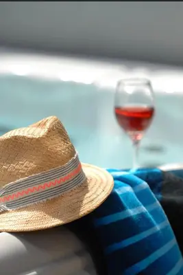 a straw hat sitting next to a glass of wine at Lakeside House on Retallack Resort with Hot Tub 110 in Padstow