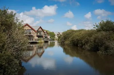 a river with houses on the side of it at Lakeside House on Retallack Resort with Hot Tub 110 in Padstow